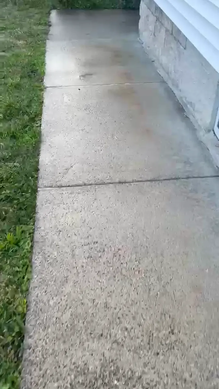 Calçada de concreto limpa depois da lavagem com alta pressão, com a superfície clara sem a sujeira do inverno
